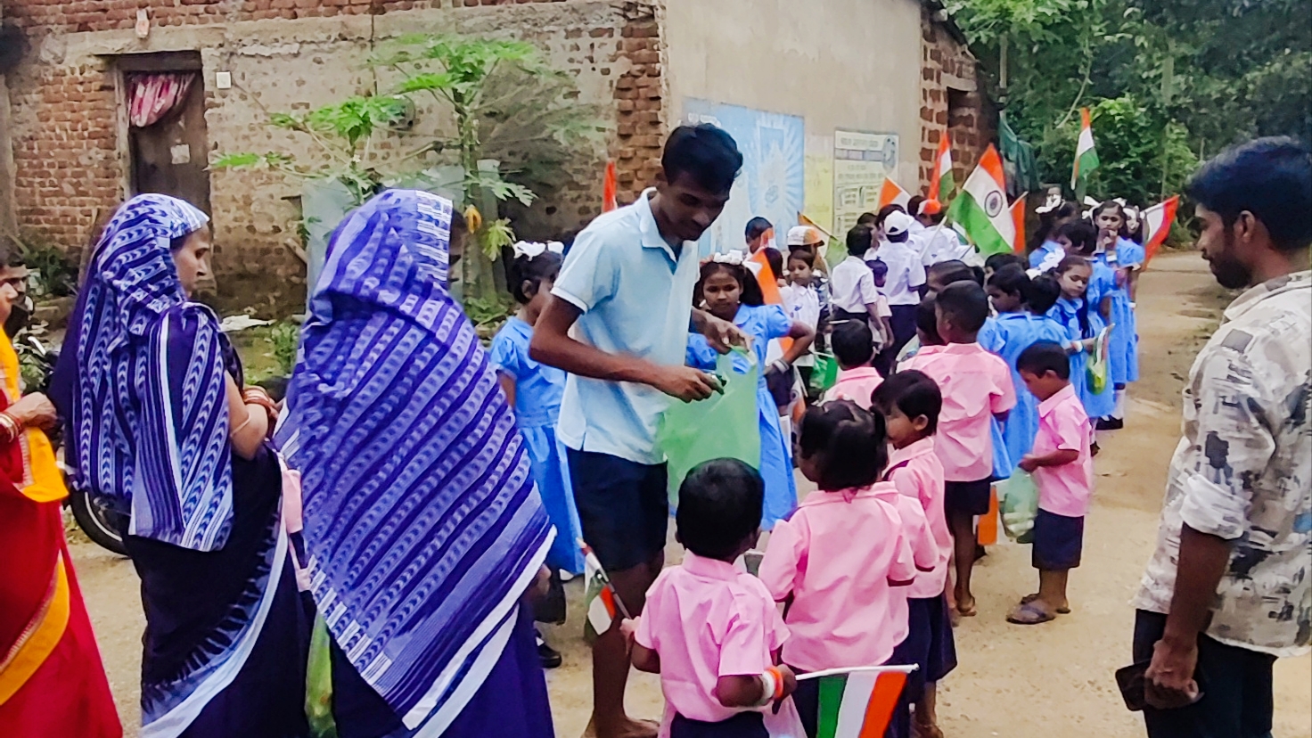Biscuit distribution to school students during village parade